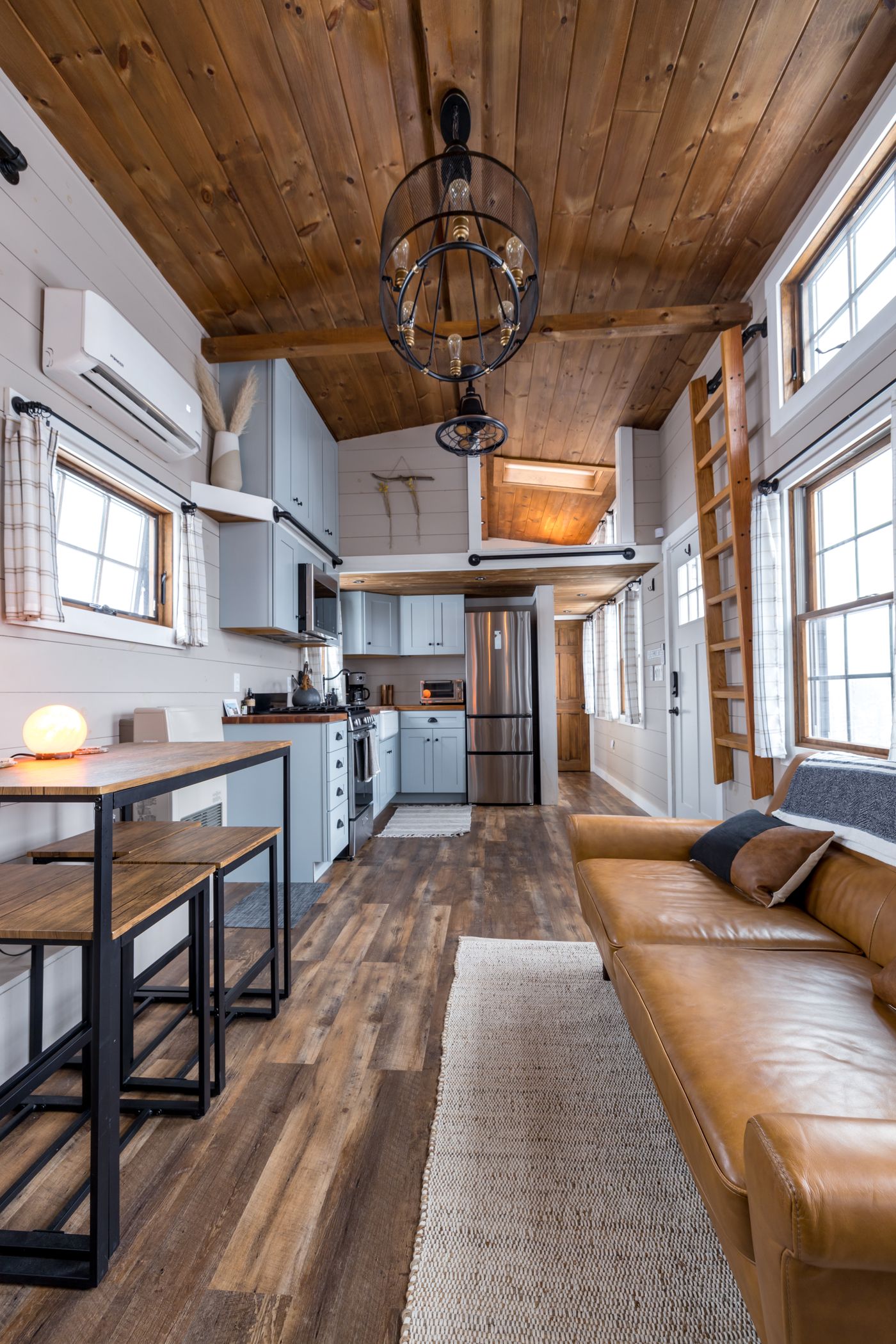 Bright tiny house interior with kitchen, loft and living space