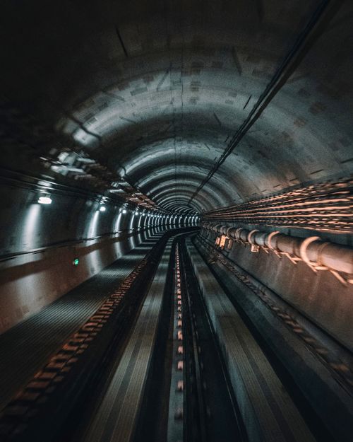 Free Explore the depths of a dimly lit underground train tunnel, capturing its industrial essence. Stock Photo