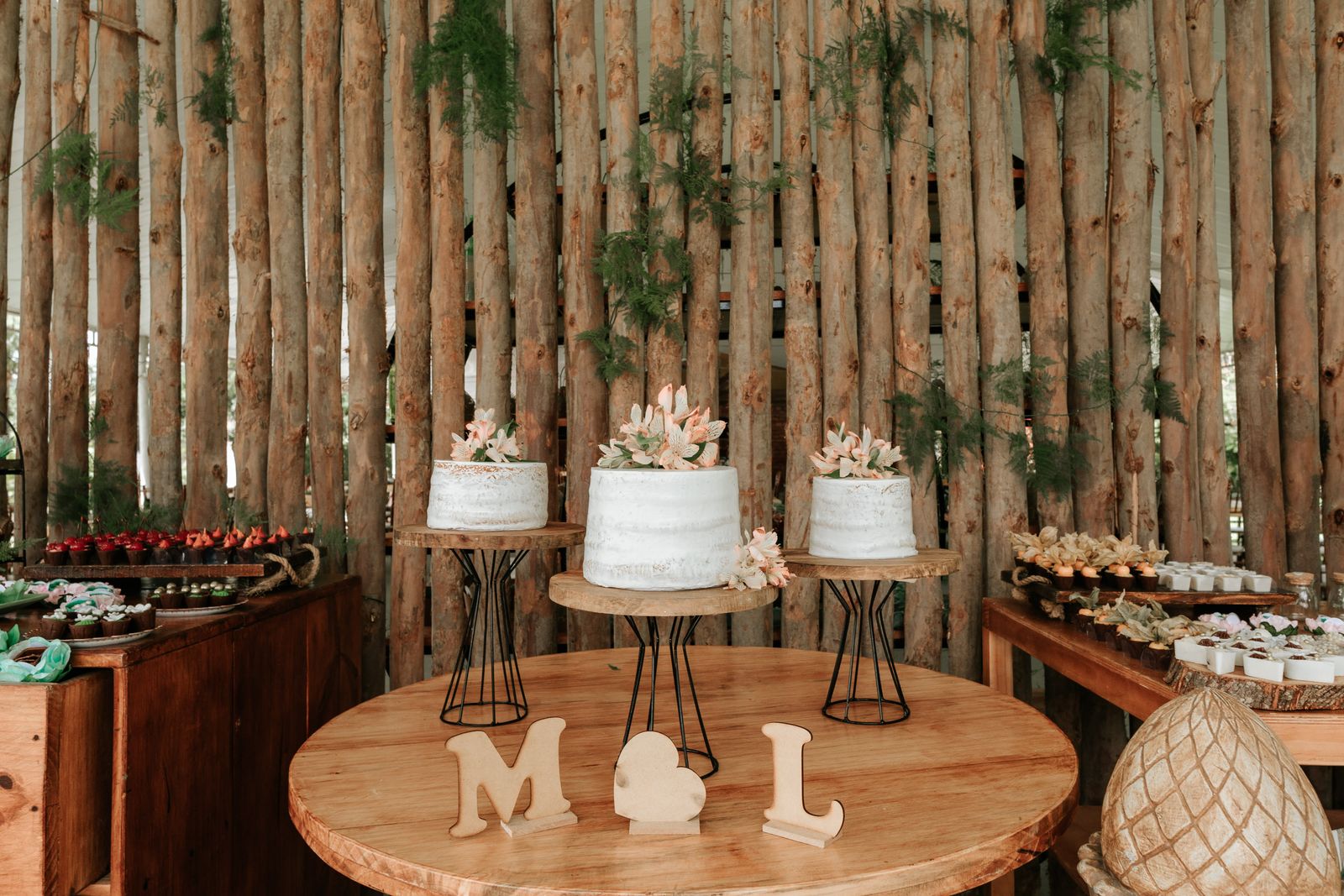Elegant boho-style cake setup with floral designs and rustic background.