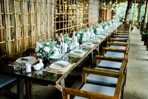 Free Beautifully arranged wedding table setting in rustic venue in Dalat, Vietnam, adorned with floral decor. Stock Photo
