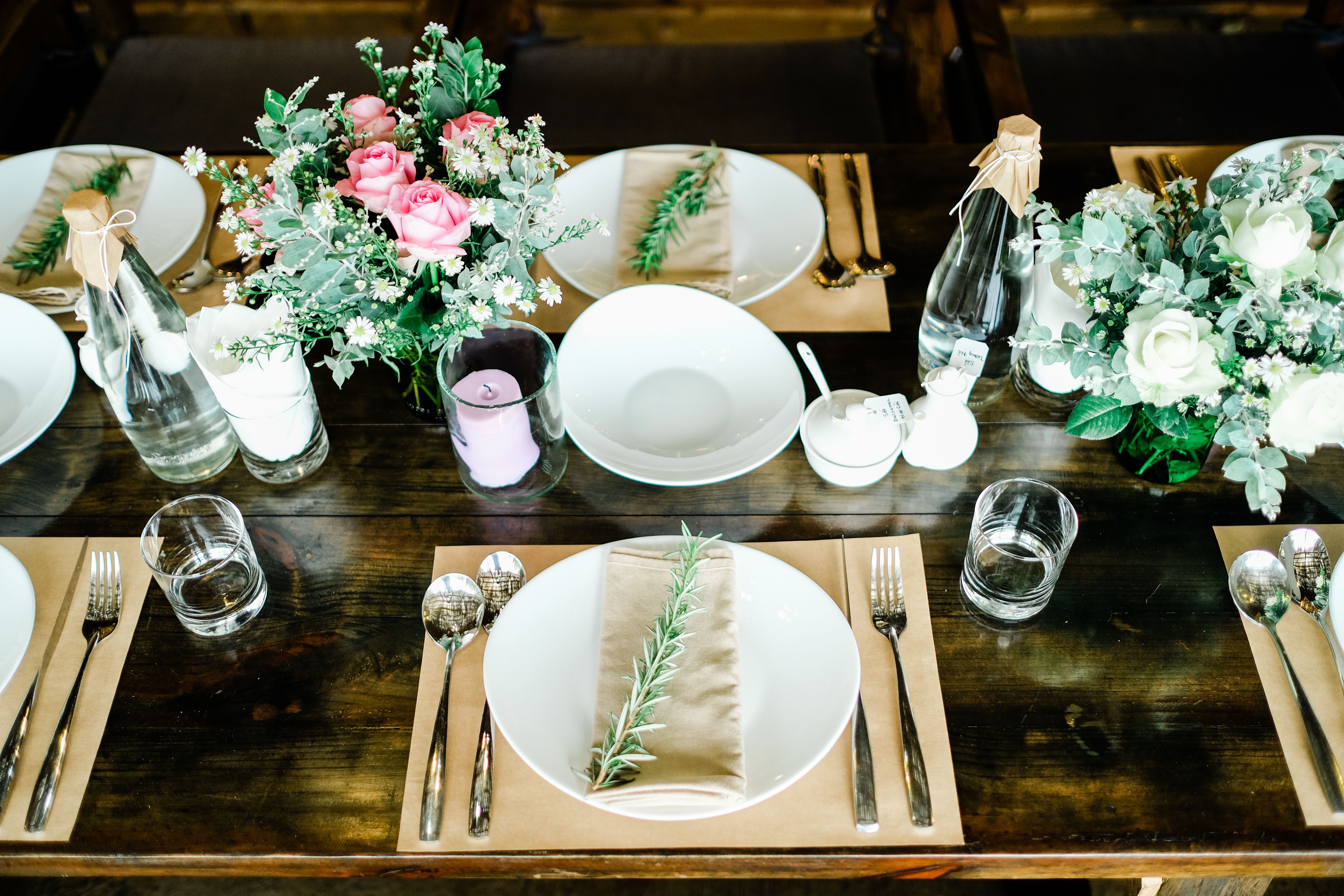 A beautifully arranged table setting with floral centerpieces and natural accents, perfect for weddings or special events.
