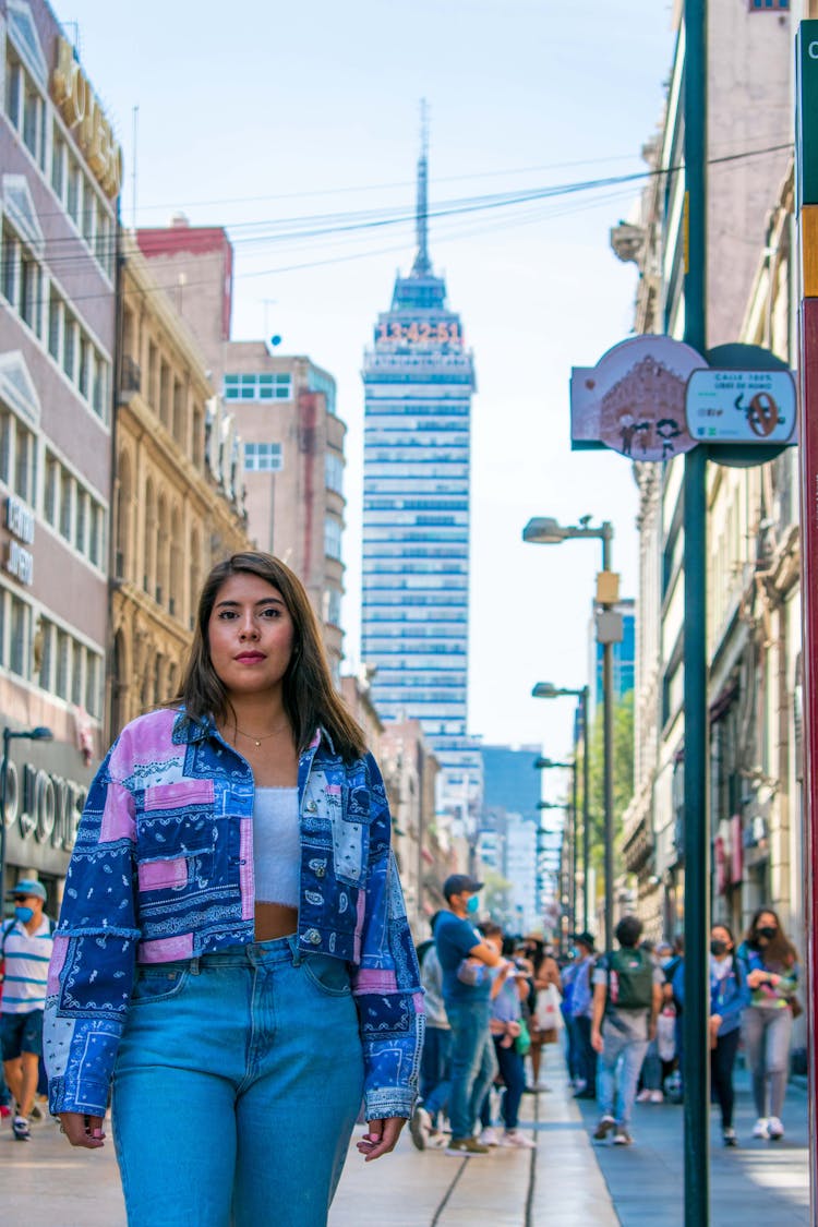 Woman In Printed Jacket And Denim Jeans Standing On Busy Street