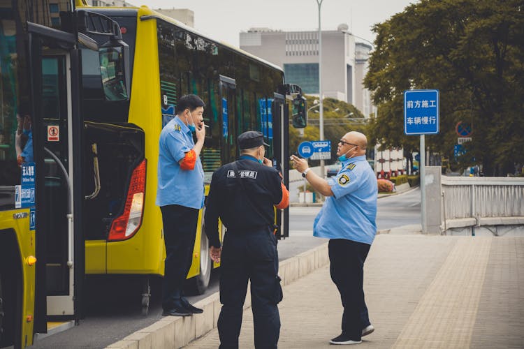 People In Uniforms Standing On Street Sidewalk Smoking Cigarette