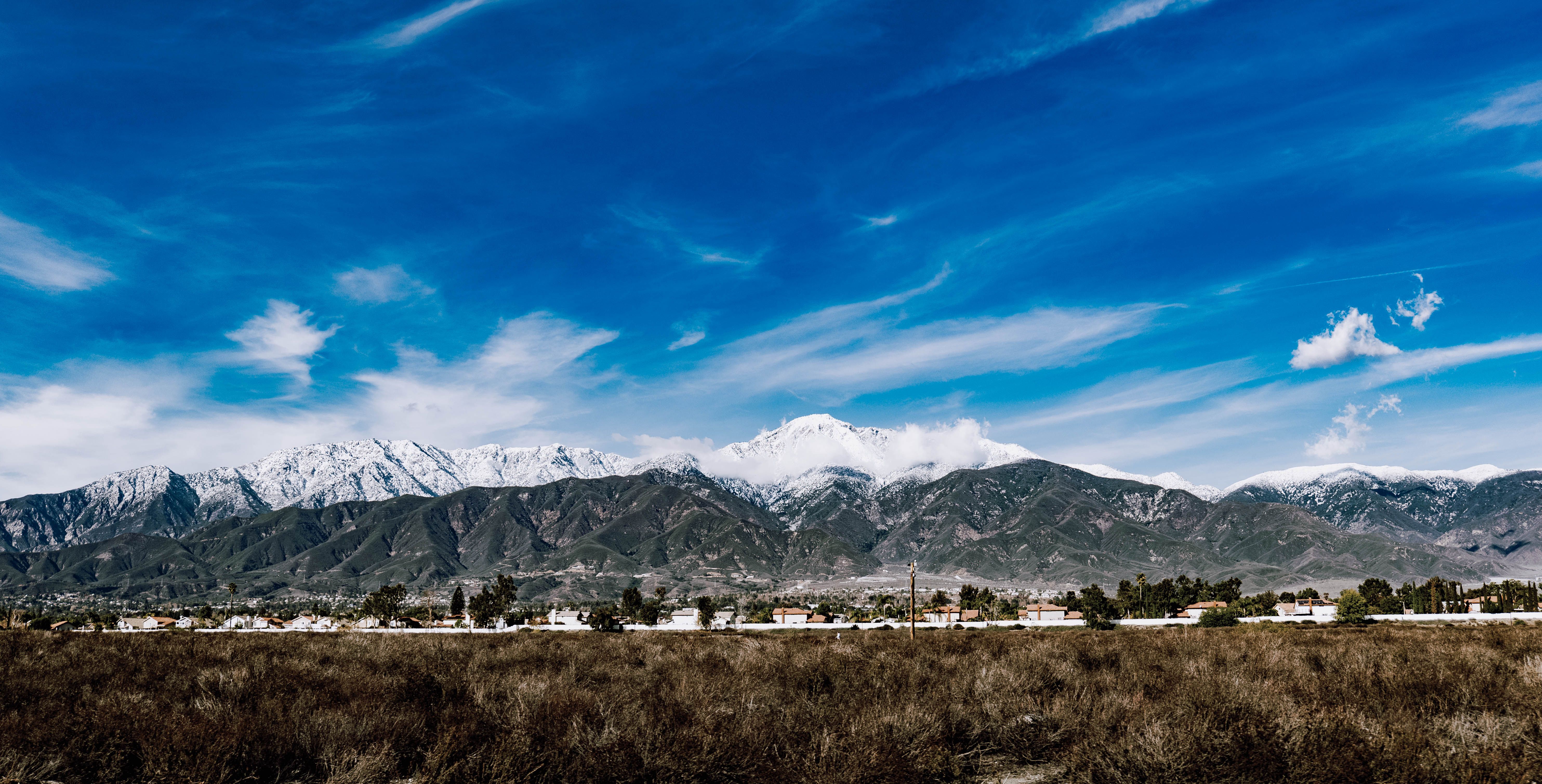 Panoramic View of a Snow Capped Mountains Under Blue Sky · Free Stock Photo
