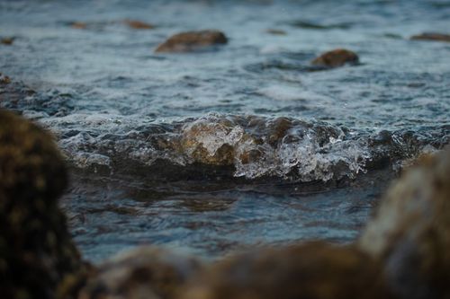 Free Calm sea waves gently crashing over rocks during daytime, showcasing nature's tranquility. Stock Photo
