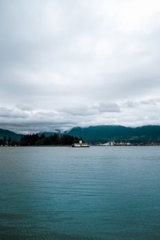 A serene view of Vancouver's waterfront with overcast skies and calm waters.