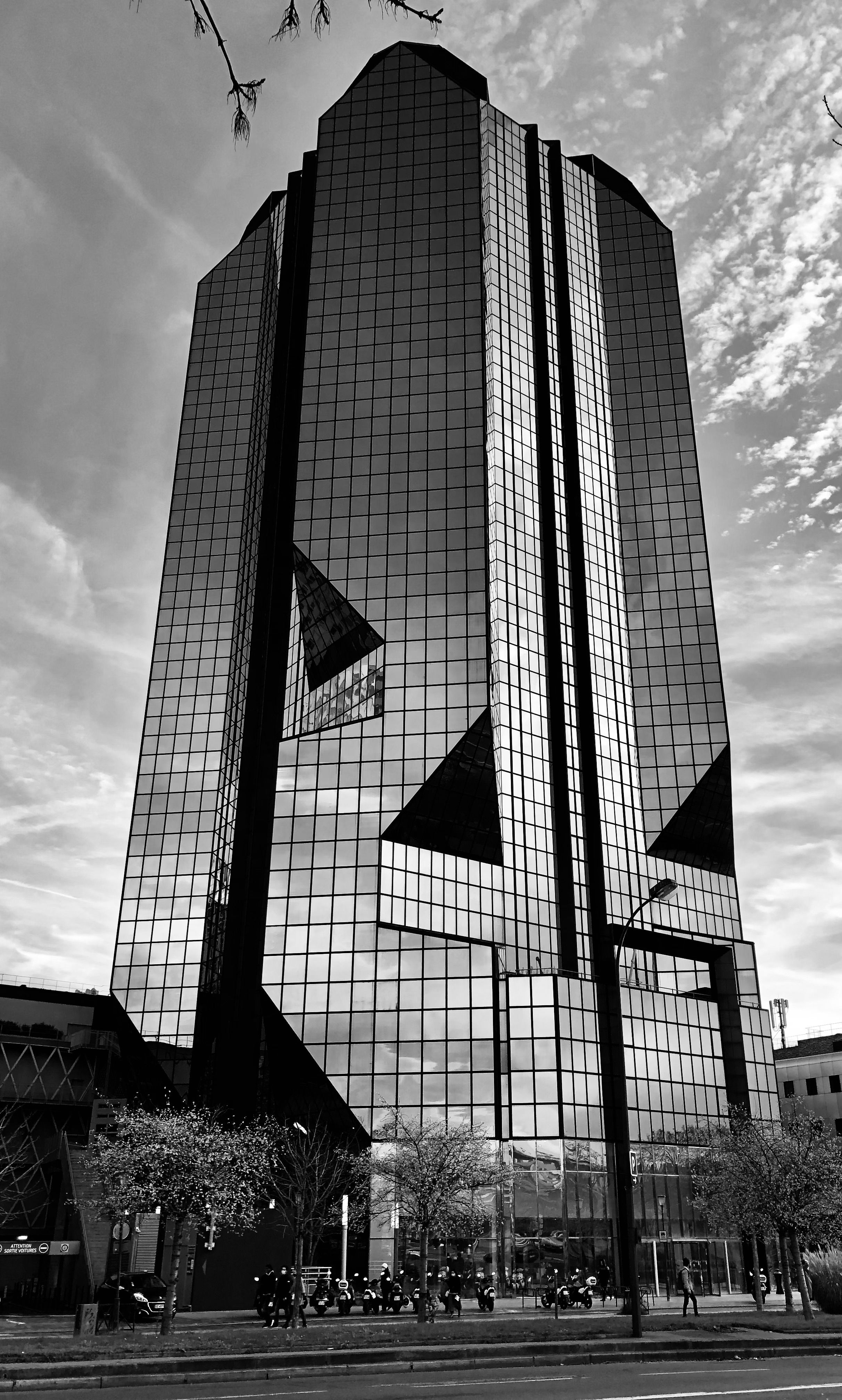 Fotomural Foto en blanco y negro de un rascacielos moderno con fachada de vidrio en París, Francia.