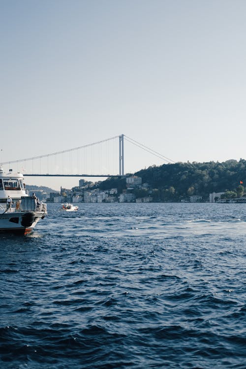 White Boat on Body of Water Near Bridge