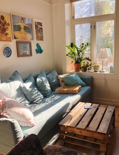 Photo by Merve Bayar on Pexels Bright and inviting living room with a blue sofa, wooden table, and decor plants by the window.