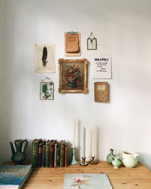 A charming vintage home interior featuring books, art, and decor on a wooden table.