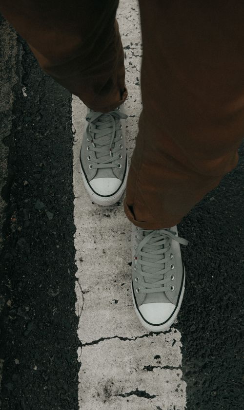 Free Top view of sneakers on a city crosswalk, highlighting street style fashion. Stock Photo