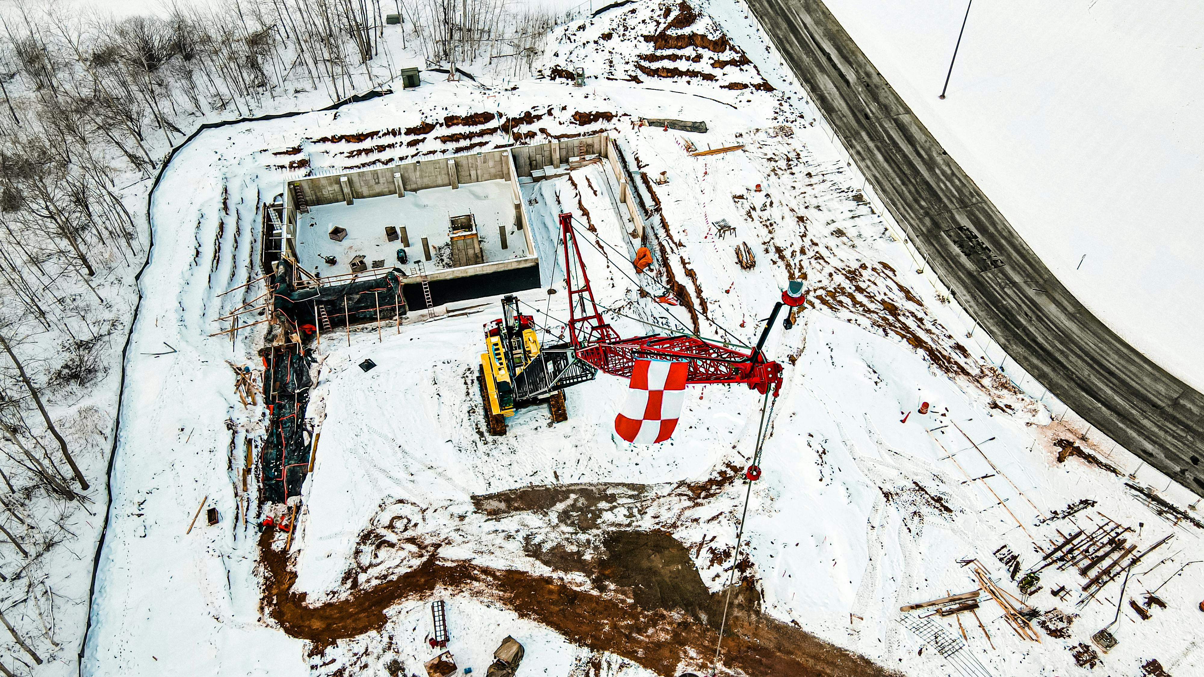 a crane equipment at a construction site on snow covered ground