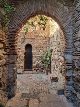 Scenic archway in Málaga, showcasing historic architecture and rustic charm.
