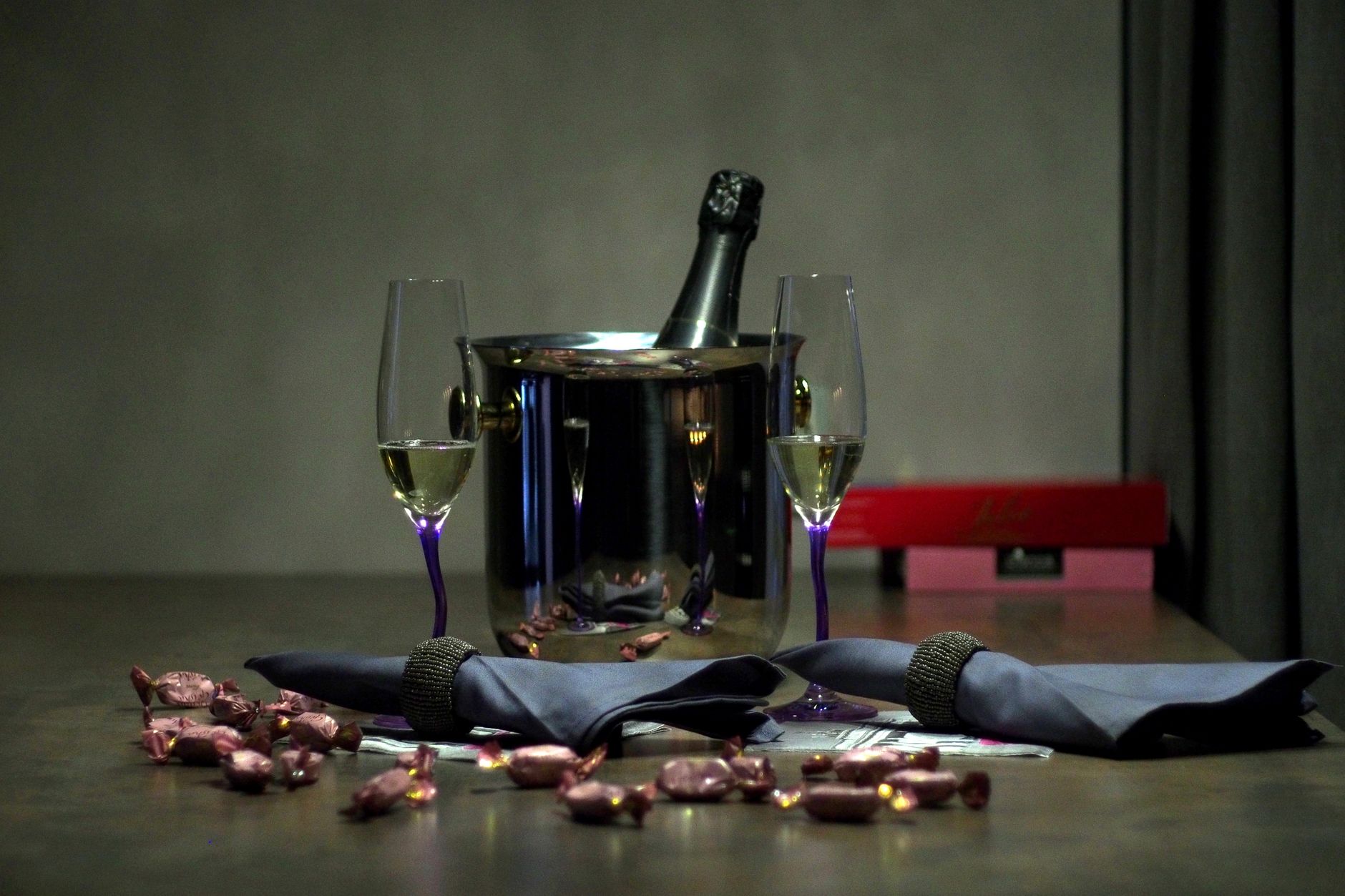 Elegant champagne setup featuring glasses, a bottle on ice, and wrapped candies, ideal for celebratory events.