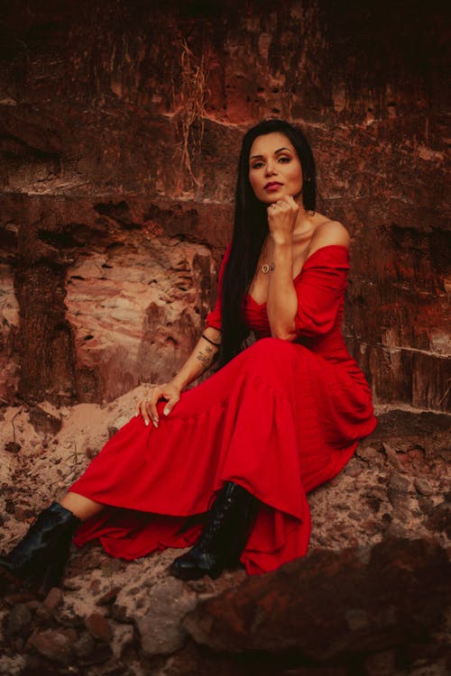 Woman in a Red Dress Sitting on a Rock 