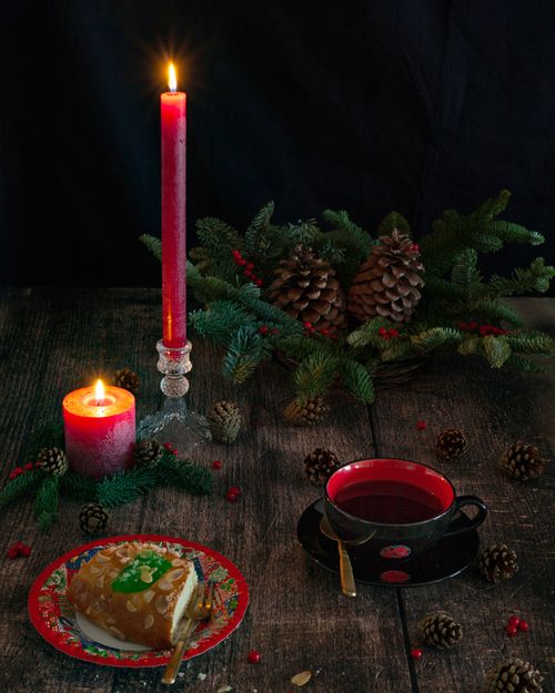 Free Festive Christmas setting with burning candles, holiday decorations, and a sweet dessert. Stock Photo