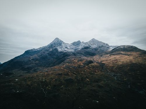 Free A breathtaking view of a rocky mountain landscape under a cloudy gray sky. Stock Photo