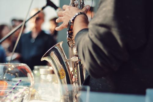 Free A saxophonist playing music at an event with an audience in the background. Stock Photo