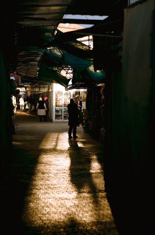 Free Mystical atmosphere with silhouettes in a sunlit urban market alley during golden hour. Stock Photo