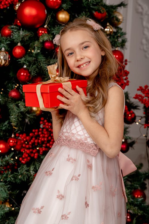 Free A Girl in Pink Dress Holding a Gift Box Stock Photo