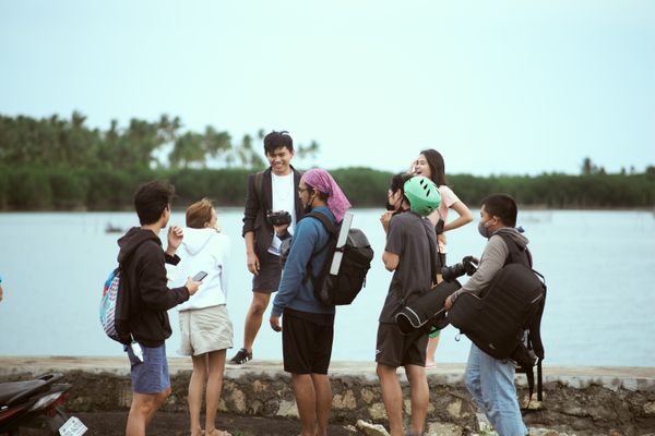 A group of friends with backpacks gathered at the water&rsquo;s edge &mdash; The Complete Group Travel Planning Guide