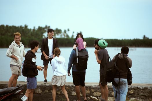 A group of young friends enjoying a playful moment near a lake, expressing happiness and friendship.