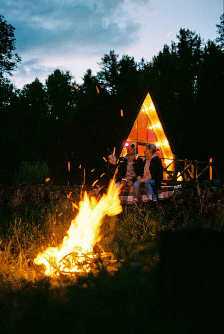 A Family Sitting Beside The Bonfire