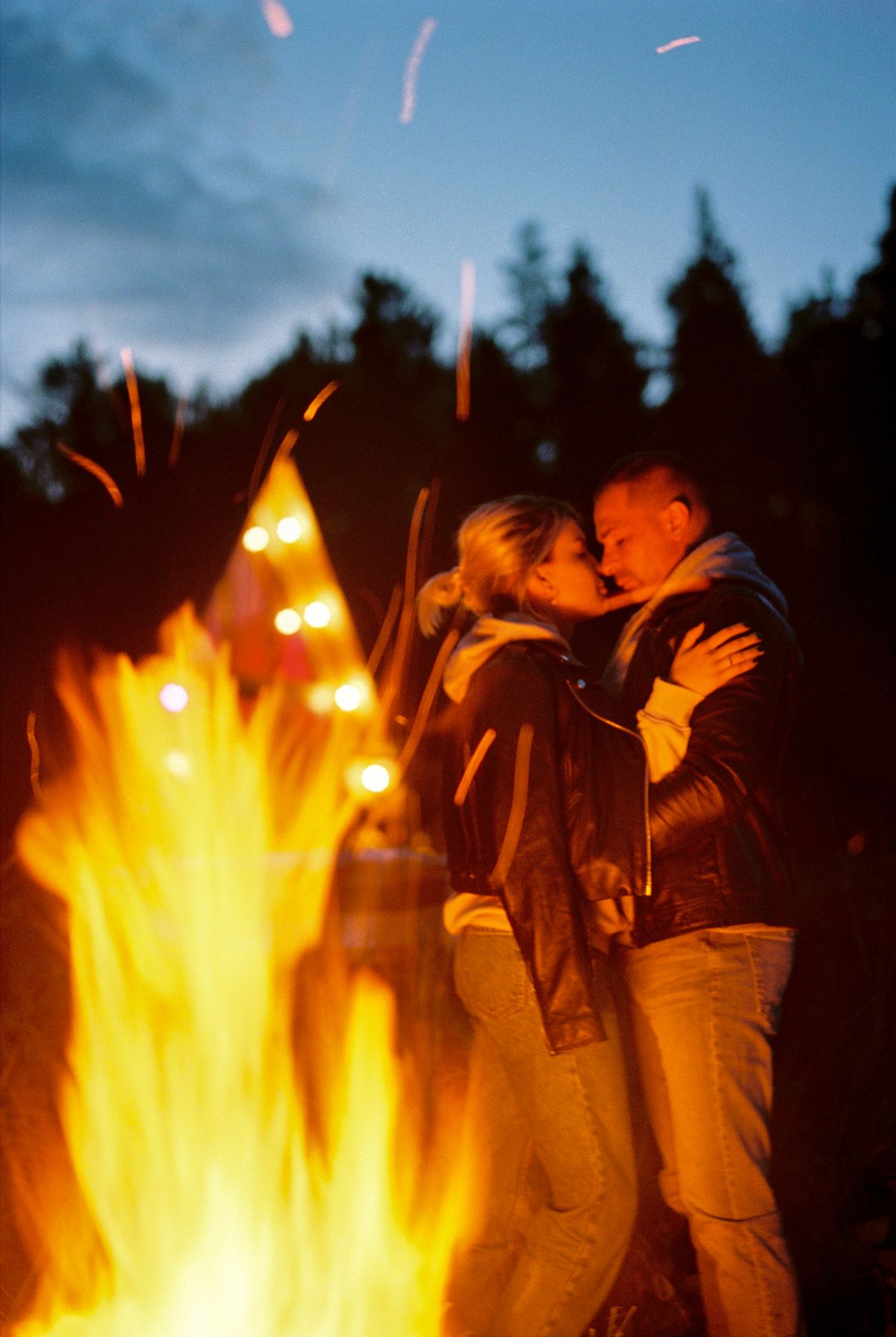 Couple by a fire at night