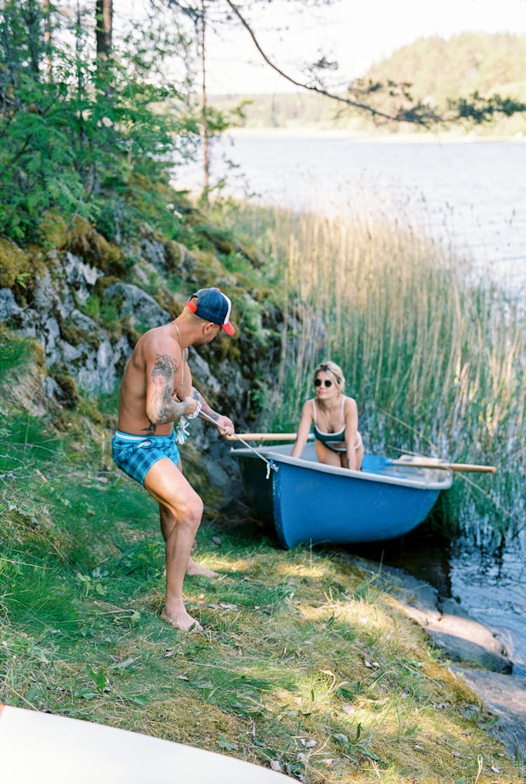 Man Pulling A Paddle Boat On Lakeside