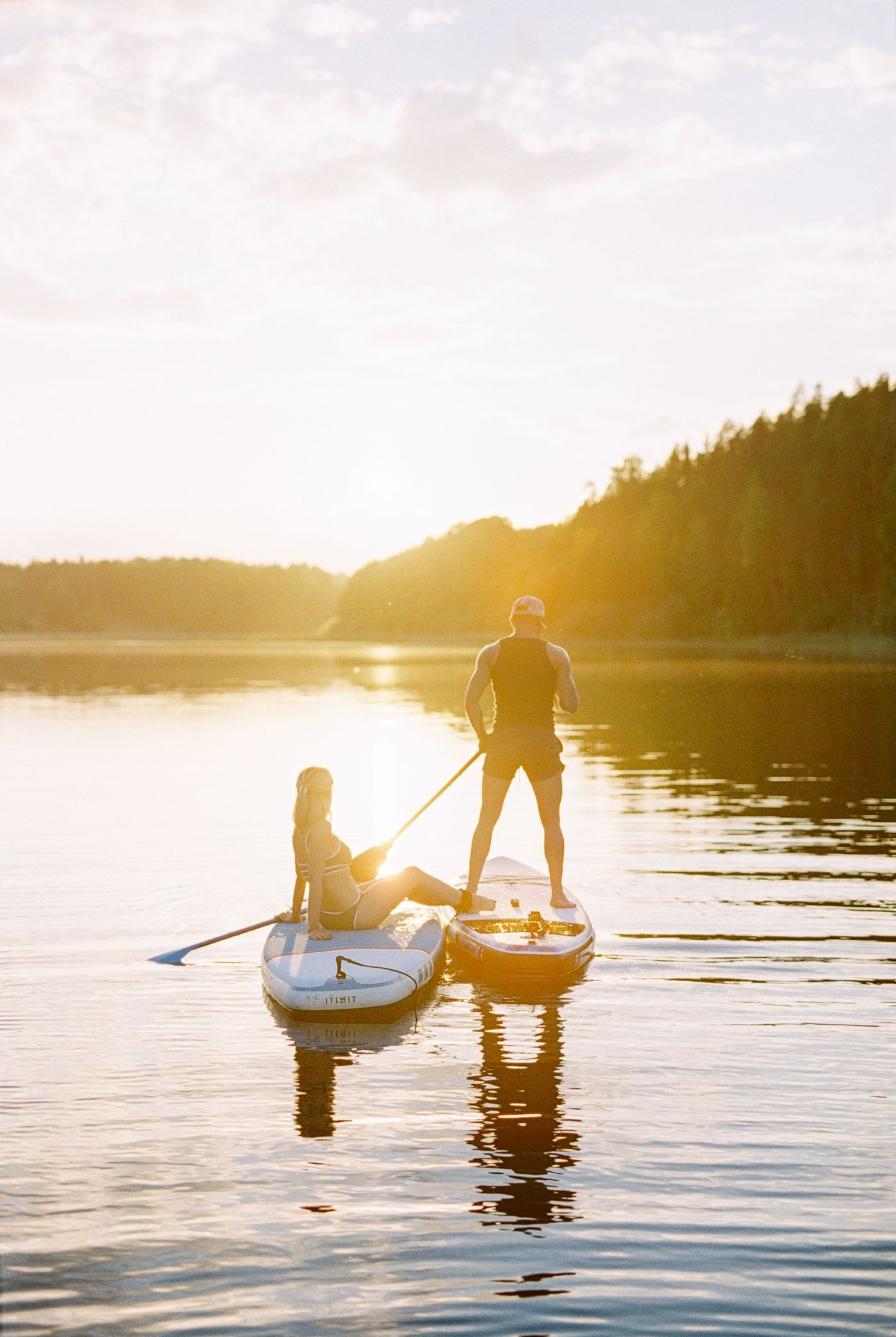 Two paddlers sharing a calm sunset route on a lake