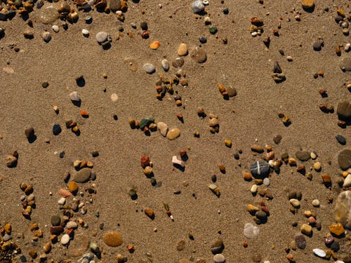 Peebles and Stones on Brown Sand