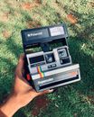 Black Polaroid Camera on Green Grass