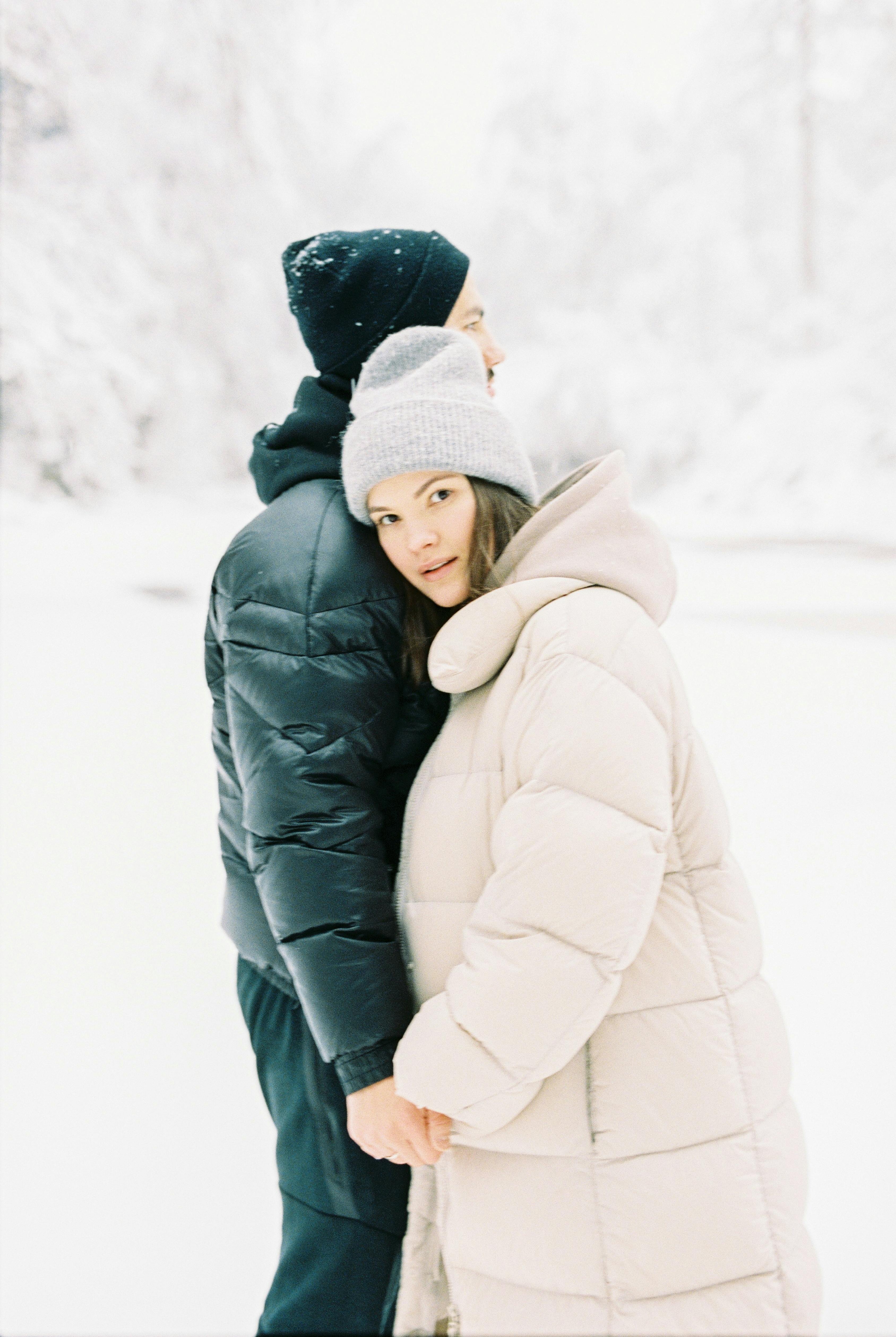 man and woman in winter coats embracing
