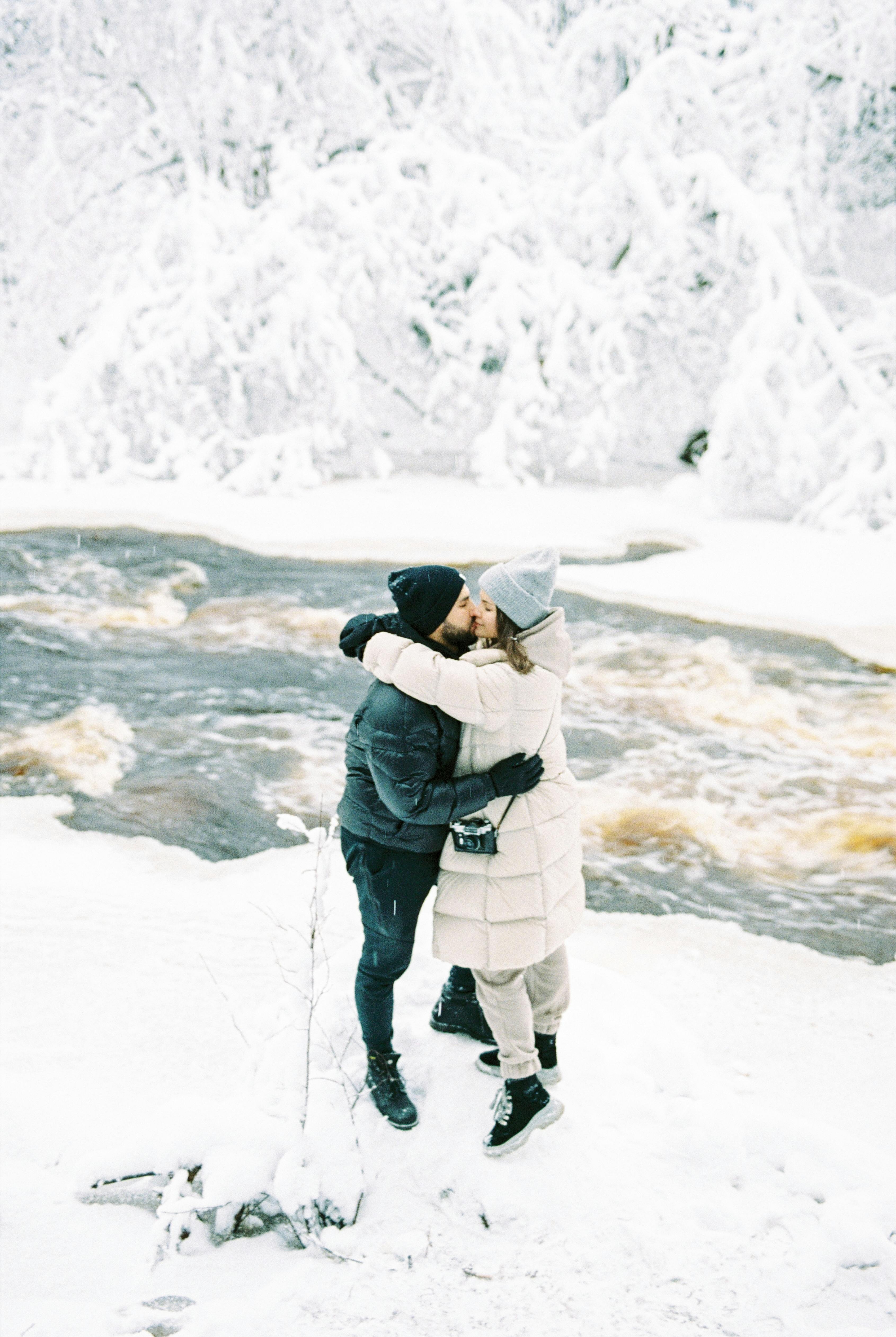 Portrait of smiling couple in love are sitting in snow. Young happy couple  walking in winter Stock Photo - Alamy