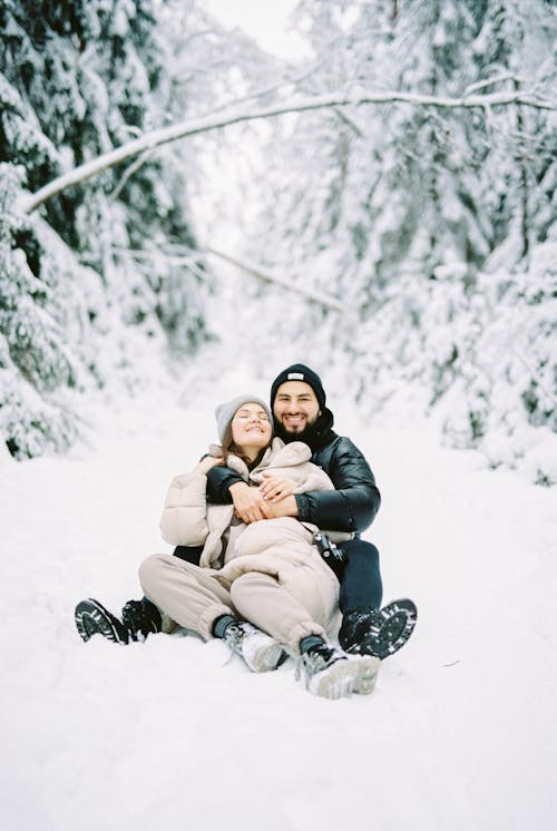 Free Portrait of Couple Sitting Together on Snow Stock Photo