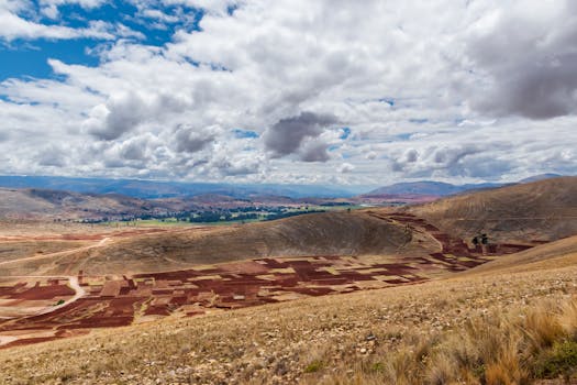 Breathtaking aerial view of patchwork fields in Jauja, Peru, under a vibrant sky.