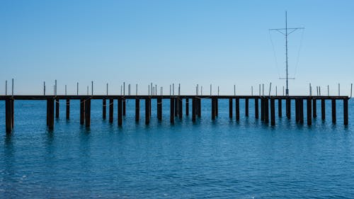 A Pier on Blue Water Under Blue Sky