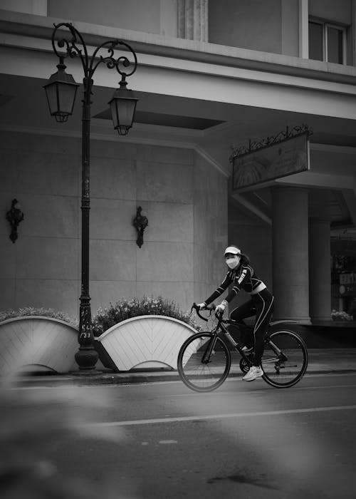 Grayscale Photo of Woman Riding Bicycle
