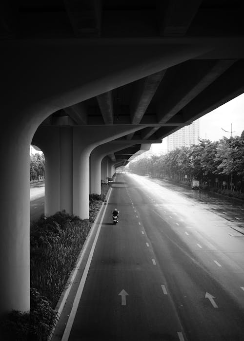 Grayscale Photo of a Person Driving Motorcycle on the Road