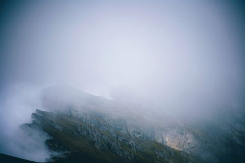 Free Dramatic fog envelops a rugged mountain peak, creating a mystical and serene atmosphere. Stock Photo