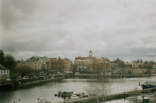 Aerial view of Vyborg, Russia, showcasing historic architecture and a serene river under cloudy skies.
