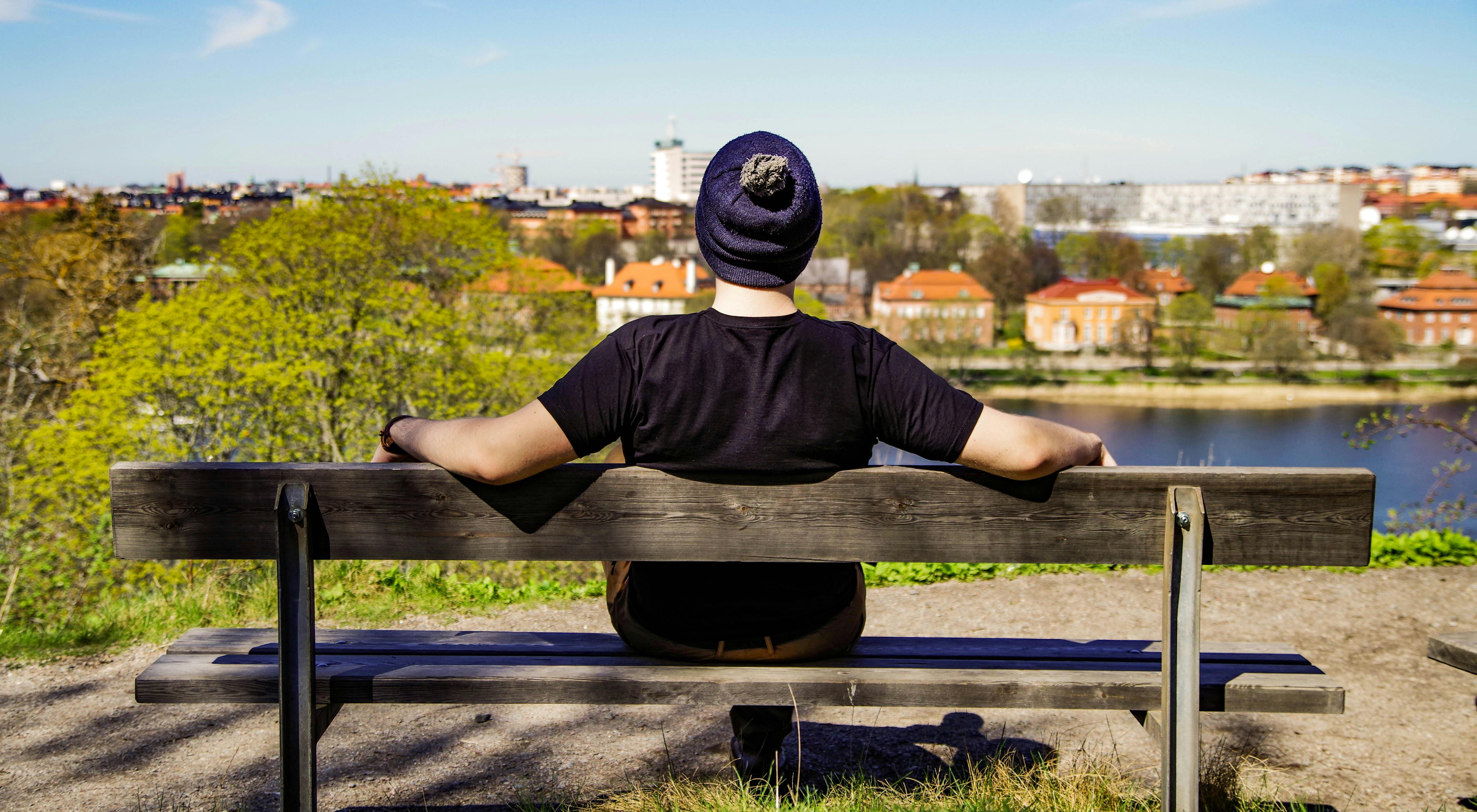 Person Sitting On Brown Bench Free Stock Photo