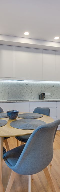Pale Scandinavian kitchen with round oak table — photo by Viaceslav Kat on Pexels