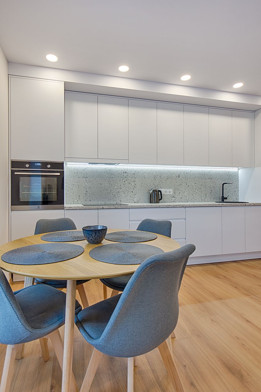 Scandinavian style kitchen with pale timber cabinetry and simple open shelving