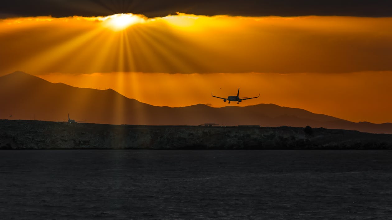 Silhouette of Airplane over Body of Water