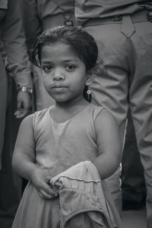 Free Monochrome portrait of a young girl standing among people in Dhaka, Bangladesh. Stock Photo
