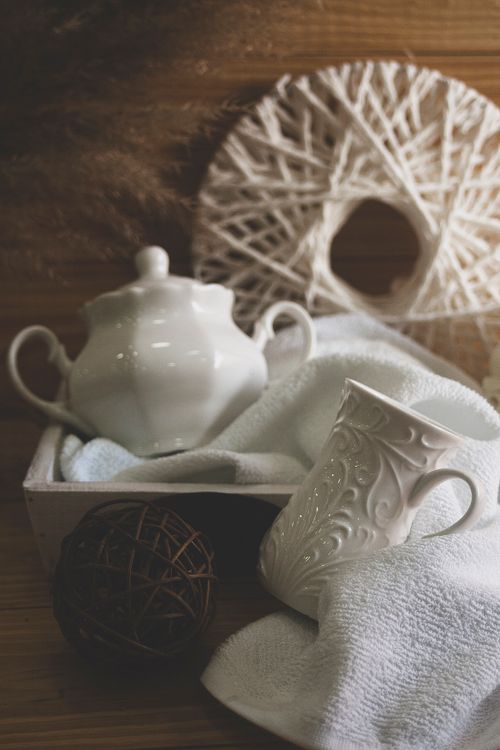 Free Aesthetic still life featuring a ceramic teapot and mug on soft fabric. Stock Photo