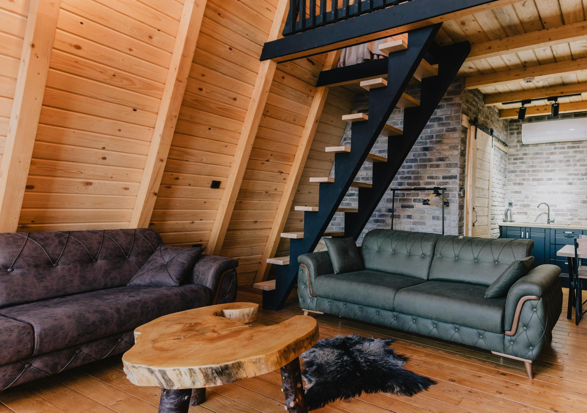 Warm and inviting log cabin interior featuring rustic furniture, wooden walls, and modern kitchen amenities.