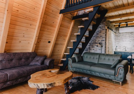 Log cabin living room with loft stairs, by Ata Ebem on Pexels