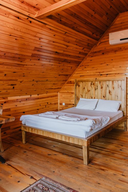Free A cozy wooden bedroom interior with rustic elements emphasizing natural aesthetics. Stock Photo